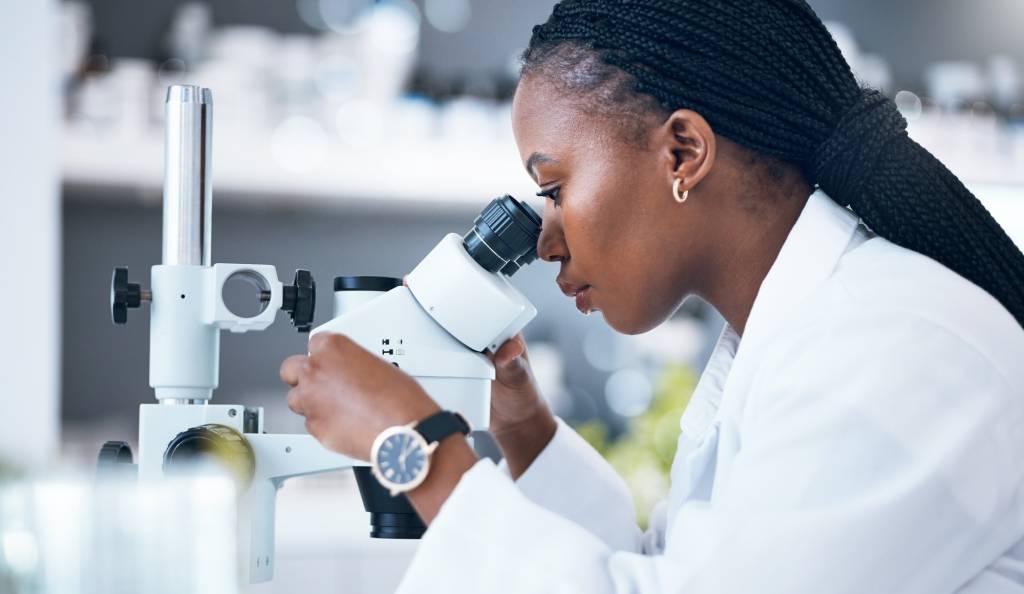 Black woman, medical science and microscope in laboratory for research, analytics and medicine. Wom